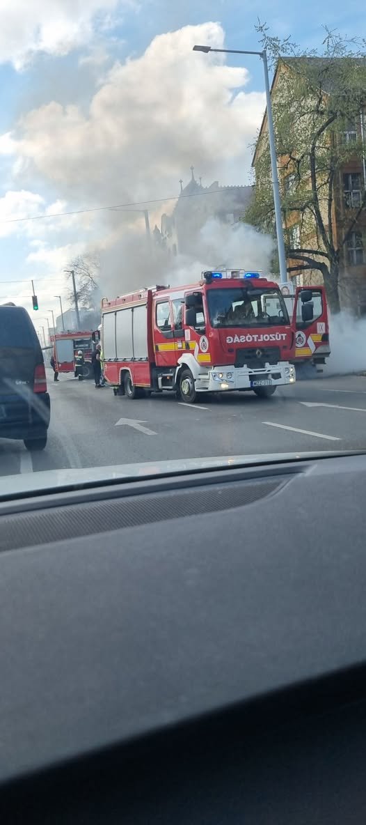 Tűzoltók oltanak egy kigyulladt dobozos járművet az Elnök utcában, sűrű füsttel borított útszakaszon.